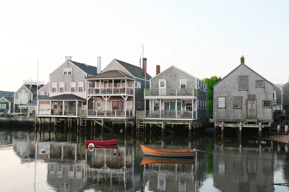 Waterfront houses reflected in calm water in Nantucket